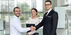 three business people shaking hands in an office