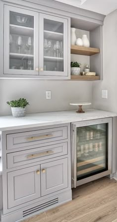 a kitchen with gray cabinets and white counter tops, an oven in the center is built into the wall