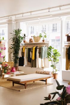 a room filled with lots of clothes and plants