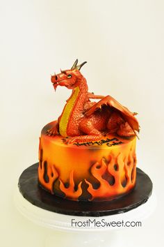 there is a cake decorated with a dragon on the top and flames in the bottom