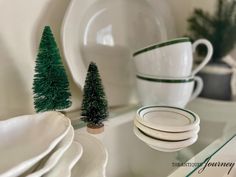 the dishes are stacked on top of each other in front of plates and christmas trees