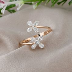 a close up of a ring on a cloth with flowers in the background and white flowers