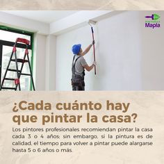 a man is painting the wall with a paint roller and a ladder in front of him