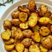 a white plate topped with potatoes on top of a table