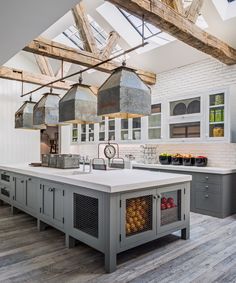 a large kitchen with an island and lots of lights hanging from it's ceiling