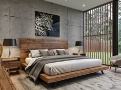 a bedroom with concrete walls and wooden furniture, including a large bed that has a leopard painting on the wall above it