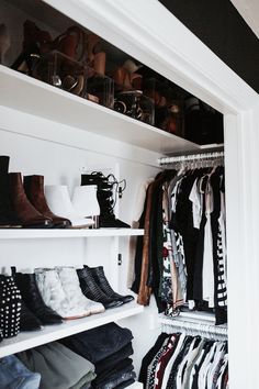 a closet filled with lots of different types of shoes and clothing hanging on white shelves