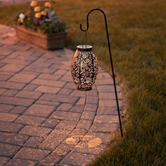 a garden light sitting on top of a brick walkway