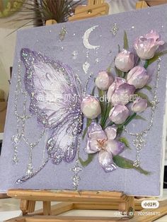 an easel with some flowers and a butterfly painted on it's back side