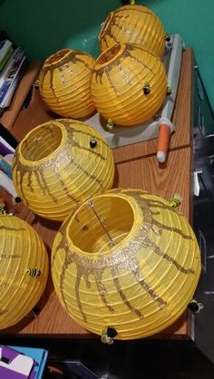 three yellow lanterns sitting on top of a wooden table next to other items in front of them