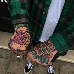 two people with tattoos on their hands and one has a flower tattooed on his hand