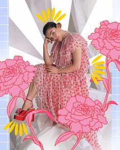 a woman sitting on top of a bed next to pink flowers