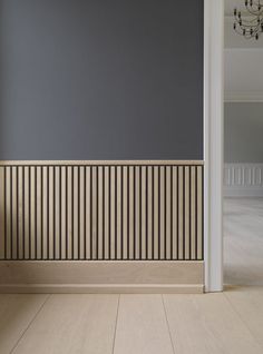 an empty room with wood paneling on the wall and wooden floor in front of it