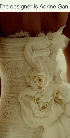 the back of a woman's wedding dress with flowers on it and text that reads, the designer is adorin gan