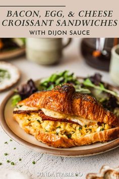 bacon, egg and cheese croissant sandwiches with dijon sauce on a plate