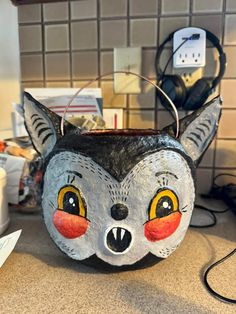 an animal mask is sitting on the counter in front of some other items and wires