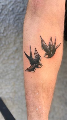 a man with a tattoo on his leg that has two birds flying in the air