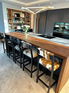 a modern kitchen with an island counter and chairs