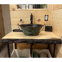 a large bowl sink sitting on top of a wooden counter next to a metal faucet