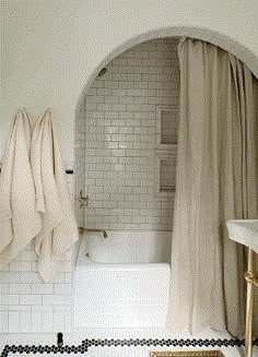 a white bathroom with black and white checkered flooring, shower curtain, and bathtub