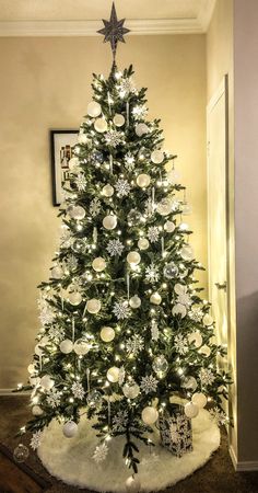 a decorated christmas tree with white and silver ornaments