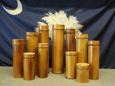 a group of bamboo containers sitting in front of a blue and white wall with a flag behind it