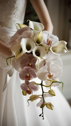 a bride holding a bouquet of white and pink flowers on her wedding day at the hotel