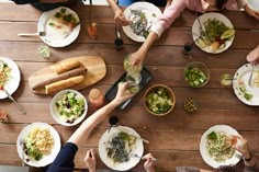 people sitting at a table with plates of food