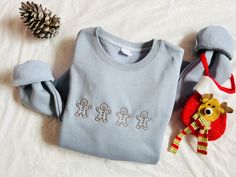 Get ready to add a touch of fun and holiday cheer to your wardrobe with our Embroidered Gingerbread Man Sweatshirt! Whether you're cozying up by the fire or enjoying festive activities, this adorable and custom-designed crewneck is perfect for bringing the spirit of Christmas to life. Sweater/Hoodie Material: cotton and polyester. Sweater/Hoodie Size: S-3XL. Please see size chart in the photo and it is unisex size. T-shirt Material: 100 % cotton T-shirt Size: XS-4XL. Please see size chart in the photo and it is unisex size. Kids Sweater/Hoodie Size: 90-150 (same size/color chart). Please see size chart in the photo and it is unisex size. Go one size up for oversized look. ♥CARE INSTRUCTIONS♥ Wash inside out, Cold Water, Do not bleach Do not iron directly on the design, Do not dry clean ♥ H Festive Activities, Polyester Sweater, Kids Tshirt, Christmas Hoodie, Men Sweatshirt, Embroidered Crewneck, Hoodie Material, Pull Sweat, Sweatshirt Christmas