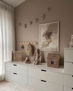 there is a stuffed animal on top of the dressers in this child's room