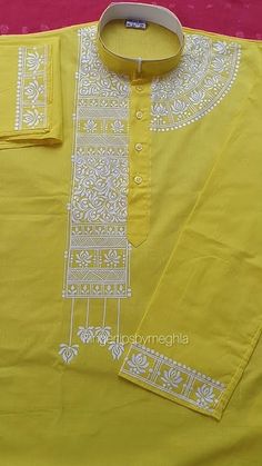 a yellow shirt with white designs on it