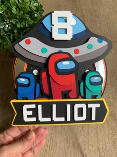 a hand holding up a sticker with an image of the word ellipot on it