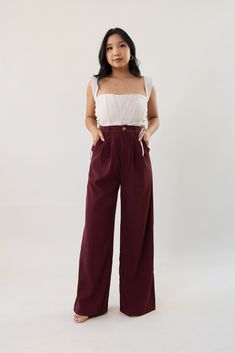 Our Run Down Trouser in maroon is a high waist loose leg trouser pant. It features a button front zipper closure, belt loop holes, and an elastic waistband at the back. It also features front pockets and faux back pockets. Pair it with our Run Down Blazer for the trendiest matching pantsuit look! Model wears a size small Model is 5'1" 100% Polyester Size small measurements: Waist: 25" Hips: 40" Inseam: 29" Maroon Trousers Outfit, Dark Red Outfit Casual, Maroon Pants Outfit Work, Red Trousers Outfit Classy, Burgandy Pants Outfits, Maroon Outfit Ideas, Red Trousers Outfit, Red Outfit Casual, Maroon Pants Outfit