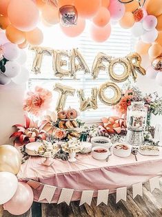 a table topped with lots of food and balloons in front of a sign that says team out