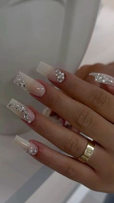 a woman's hand with some white and silver nail polishes on her nails