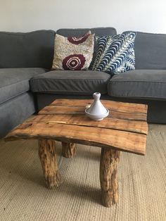 a coffee table made out of wood sitting in front of a couch