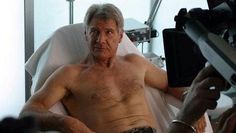 an older man sitting in a hospital bed with his arm wrapped around him and looking at the camera