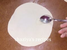 a person is using a spoon to make dough