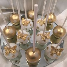 there are many cake pops with gold decorations on them