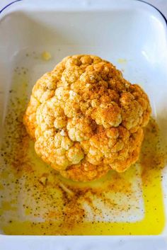 a close up of a food item in a bowl with oil and seasoning on the side