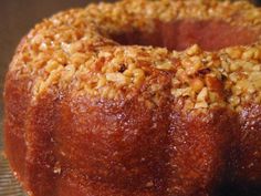 a close up of a doughnut with nuts on it's crusty surface