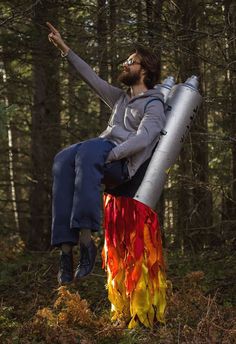 a man sitting on top of an inflatable fire hydrant while pointing to the sky