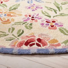 an area rug on the floor with flowers and leaves painted on it in pastel colors