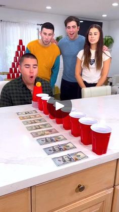 a group of people standing around a table with cups on it