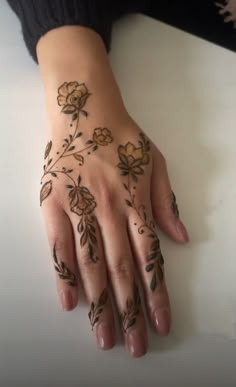 a woman's hand with hennap on it and flowers painted on the palm