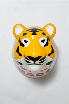 a toy tiger head sitting on top of a white surface