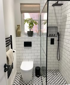 a bathroom with black and white tile flooring next to a toilet in the shower