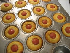 a muffin tin filled with cupcakes covered in ketchup sitting on top of a stove