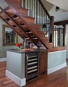 a kitchen with an island and wine rack under the stairs