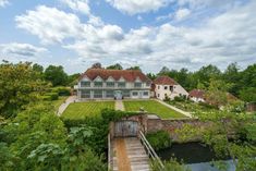 an aerial view of a large house with a bridge leading to it